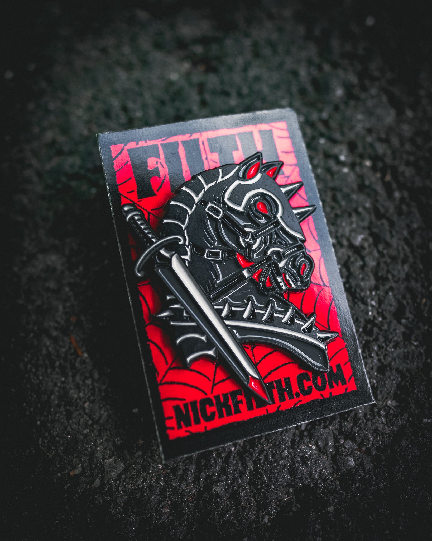 Horse-themed badge with red and black design on a textured black background