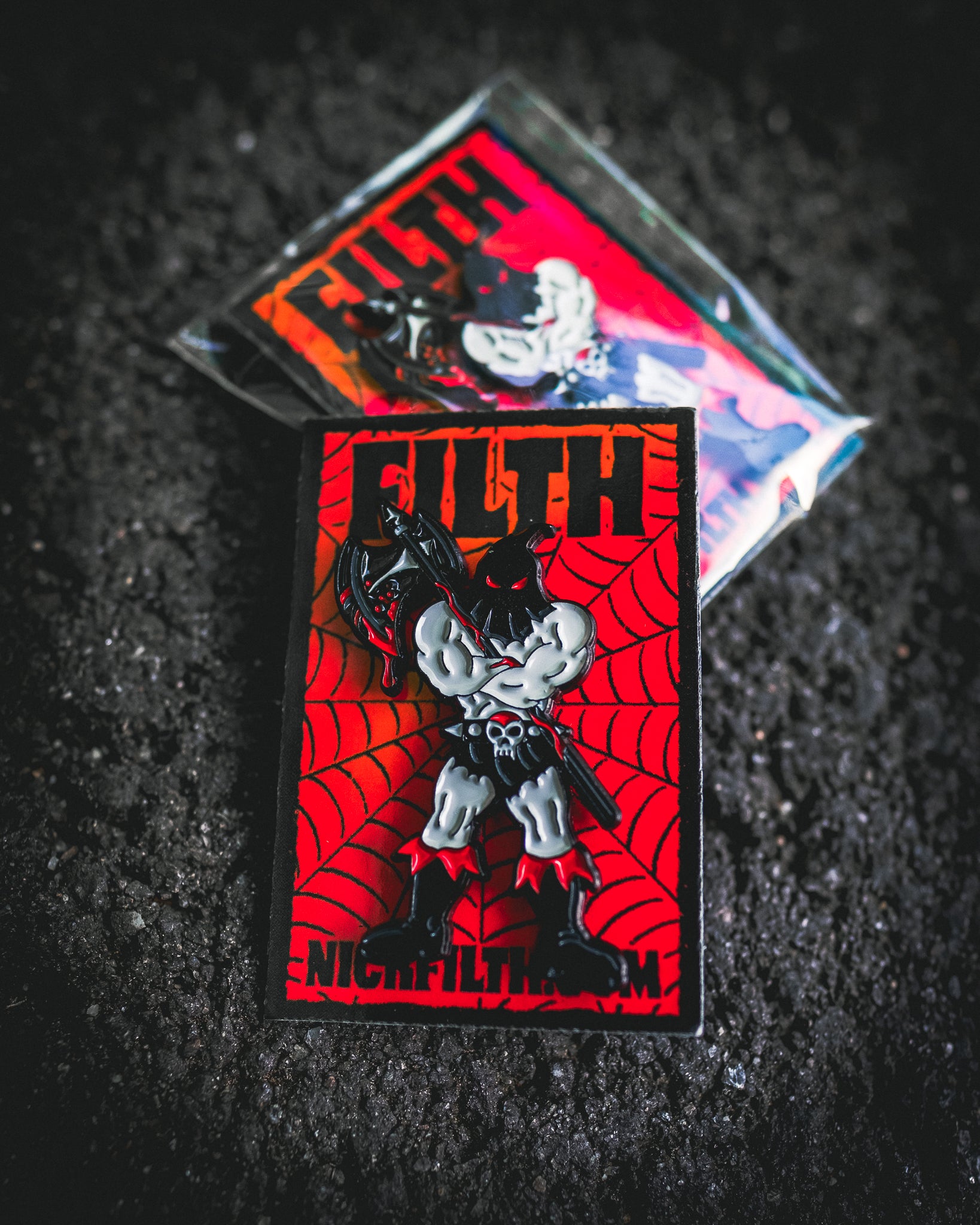 Enamel pin with 'Filth' design on a dark textured background